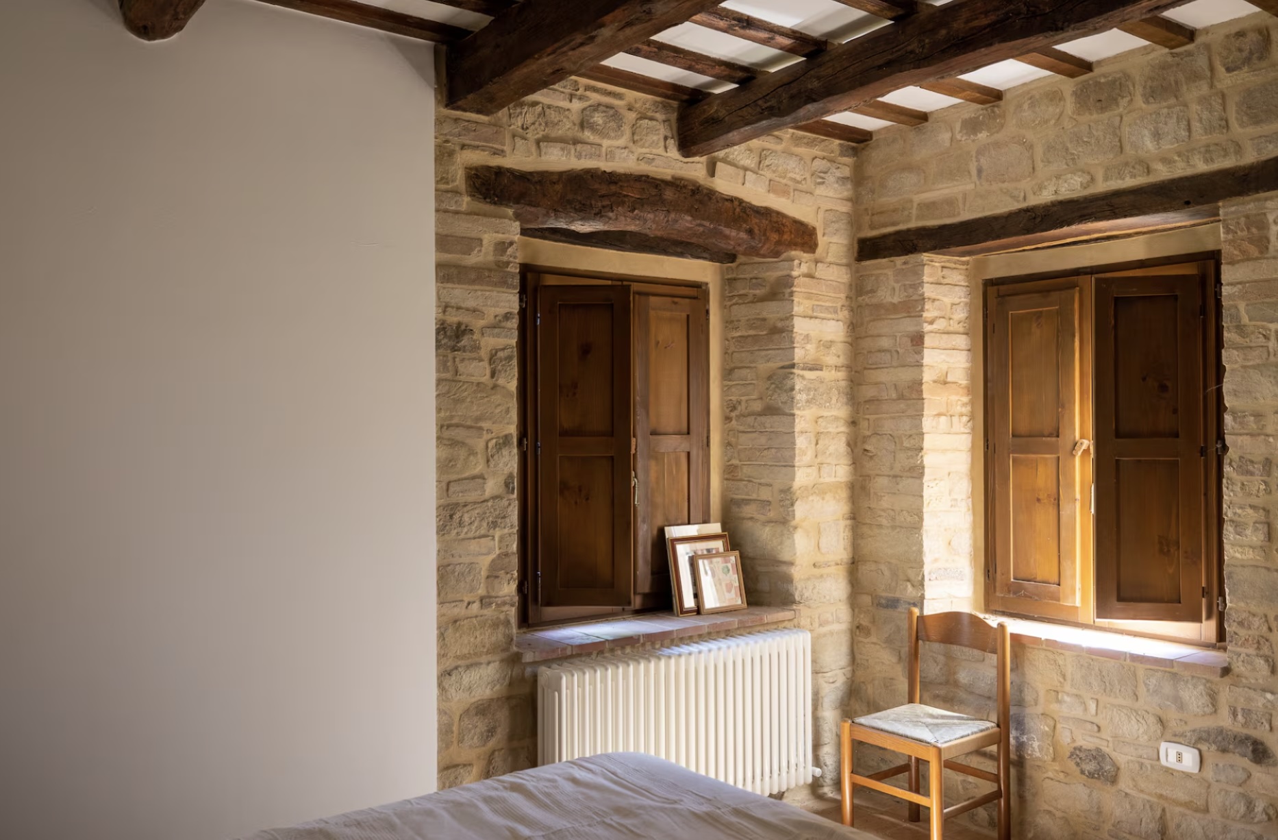 Slaapkamer met stenen muur en houten balken